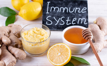 Small blackboard with ‘Immune System’ written on it, surrounded by honey, lemons, and ginger, representing natural immune support and the impact of menopause on immunity.