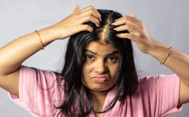 A middle aged woman looking upset about her thinning Hair